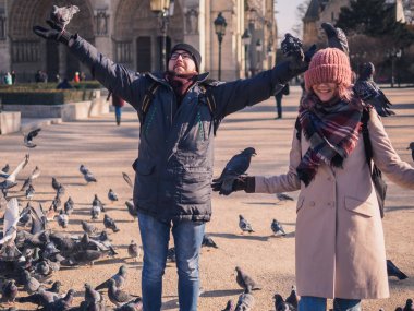 Notre Dame Katedrali önünde meydanında güvercin besleme turist
