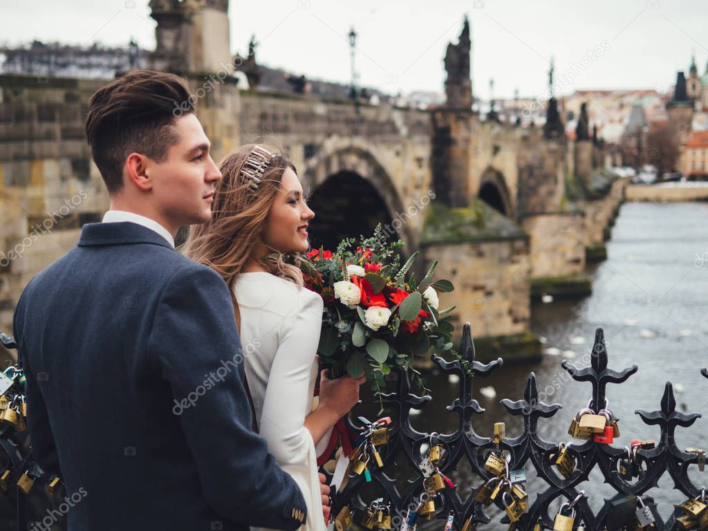 Groom and bride in charles bridge. winter wedding in Prague