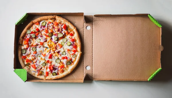 白いテーブルの上配送段ボール箱でチーズバーガー ピザ — ストック写真