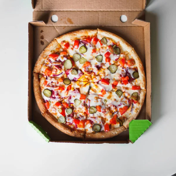 白いテーブルの上配送段ボール箱でチーズバーガー ピザ — ストック写真
