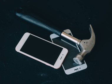 kırık ekran siyah tablo üzerinde çekiç ile Smartphone