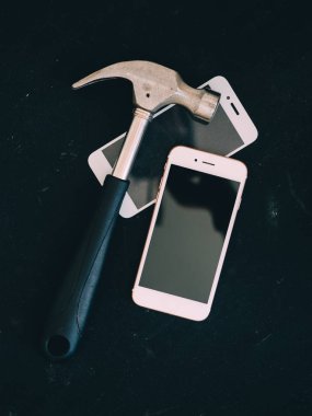kırık ekran siyah tablo üzerinde çekiç ile Smartphone