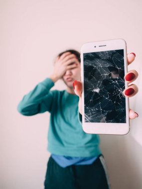 Kırık cam ekran smartphone üzgün kız, beyaz arka plan elinde