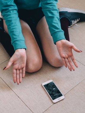 Kırık ekran smartphone karo zemin üzerinde kızla 
