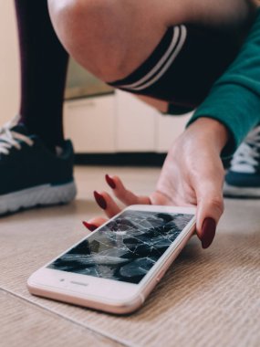 Kırık ekran smartphone üzerinde ayakkabı ile seramik zemin
