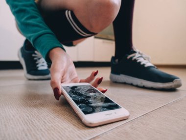 Kırık ekran smartphone üzerinde ayakkabı ile seramik zemin