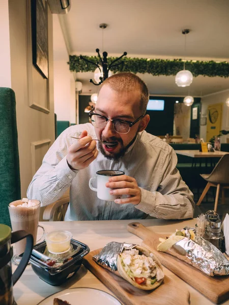 Un tipo almorzando en un café. Sopa giroscopios té de café — Foto de Stock