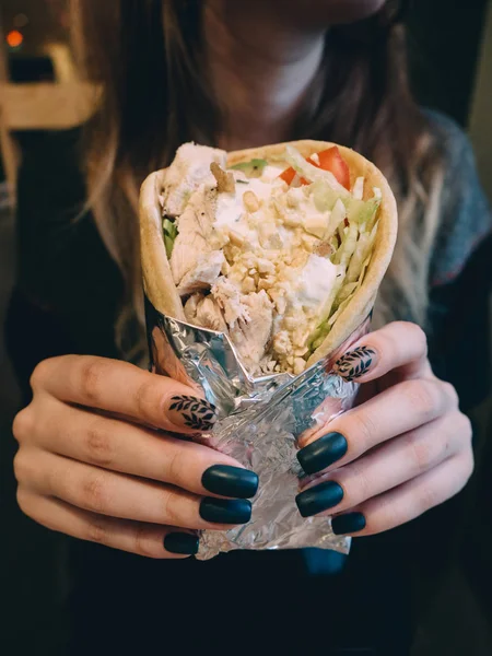 Greek meat gyros with sauce, vegetables, feta cheese and french fries in hand — Stock Photo, Image