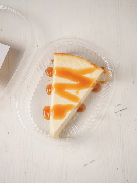 Tarta de queso blanco con caramelo en caja de plástico —  Fotos de Stock