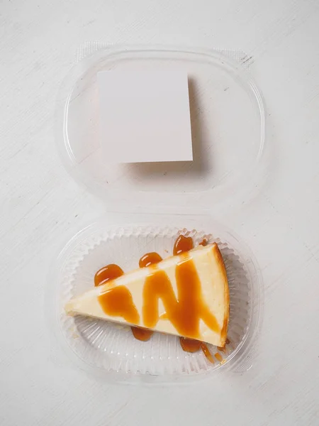 Bílý tvarohový dort s karamelem na plastové krabičce — Stock fotografie