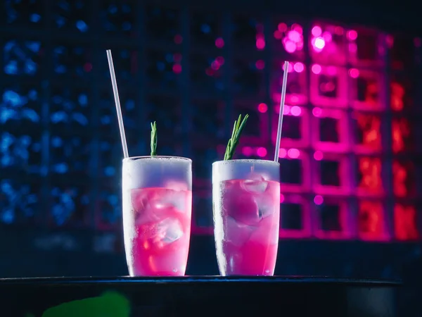 Pink alcohol cocktails with ice and rosemary — Stock Photo, Image