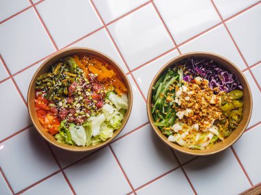 Beyaz fayans masasında et ve sebzelerle dolu kaseleri dürtün.