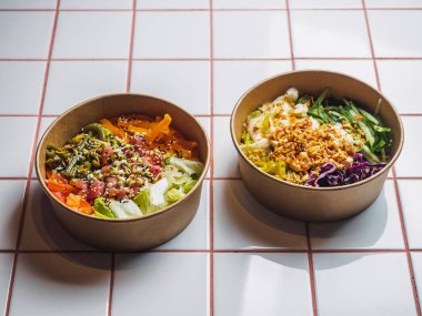 Beyaz fayans masasında et ve sebzelerle dolu kaseleri dürtün.