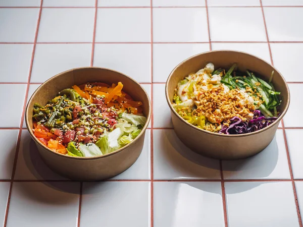 Beyaz fayans masasında et ve sebzelerle dolu kaseleri dürtün.