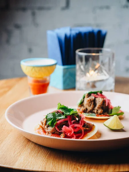 Tacos com carne, cebola, verduras, limão. placa na mesa — Fotografia de Stock