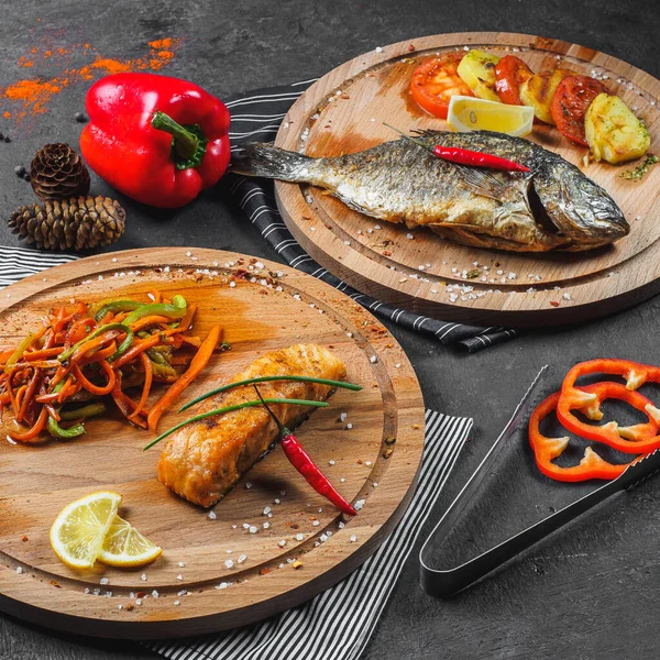 Set de dos platos de pescado con verduras en escritorios de madera — Foto de Stock