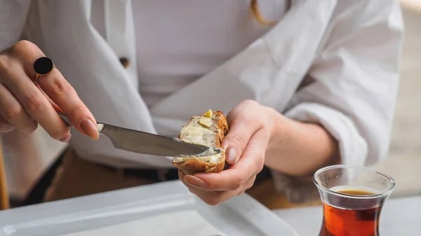 Femme tartiner de beurre sur le pain. Mains avec couteau — Photo