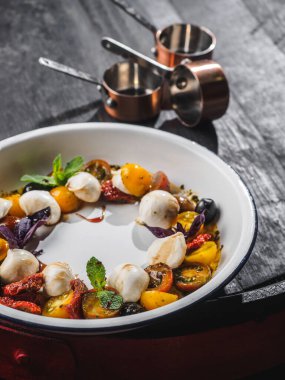 Mozzarella soslu salata ve diş minesi tabağında kiraz..