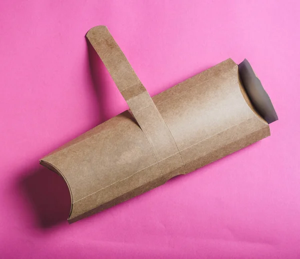 Shawarma roll in craft package on pink background. Copy space.