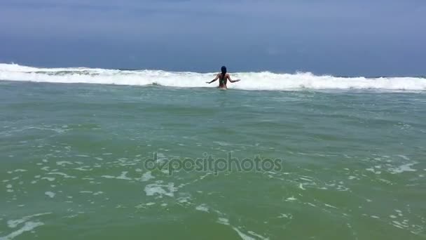 Jonge en mooie vrouw springen en spelen op de golven in de Oceaan — Stockvideo