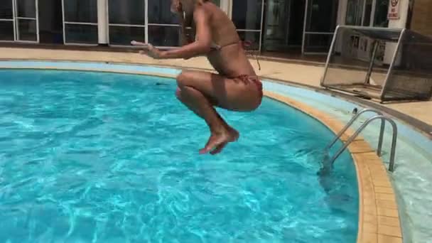 Ung kvinna hoppa i poolen — Stockvideo