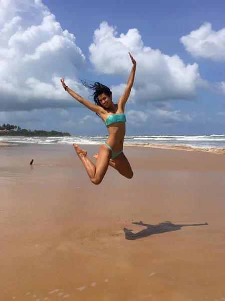 Красива жінка стрибає на пляжі — стокове фото