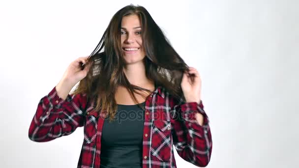 Brünette Frau spielt mit ihren langen Haaren und lächelt. Zeitlupe — Stockvideo