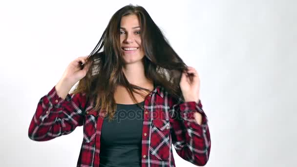 Mujer morena jugando con su pelo largo y sonriendo. Moción lenta — Vídeos de Stock