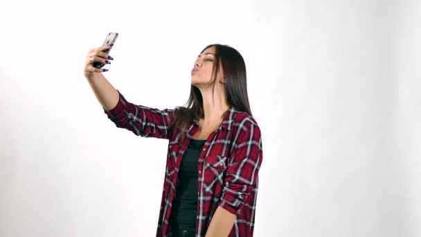 Όμορφη νεαρή γυναίκα που κάνει selfie, σχετικά με το λευκό φόντο — Αρχείο Βίντεο