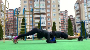 Güzel genç çift dışarıda çalışıyor plang, squat, hamleler, şınav çekiyorlar