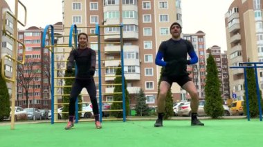 Güzel genç çift dışarıda çalışıyor plang, squat, hamleler, şınav çekiyorlar