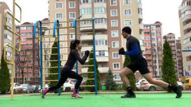 Güzel genç çift dışarıda çalışıyor plang, squat, hamleler, şınav çekiyorlar