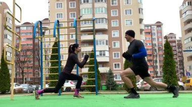 Güzel genç çift dışarıda çalışıyor plang, squat, hamleler, şınav çekiyorlar