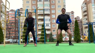 Güzel genç çift dışarıda çalışıyor plang, squat, hamleler, şınav çekiyorlar