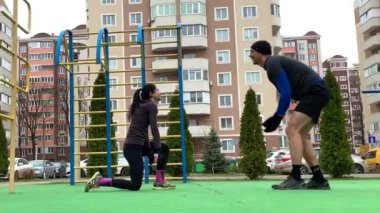 Güzel genç çift dışarıda çalışıyor plang, squat, hamleler, şınav çekiyorlar