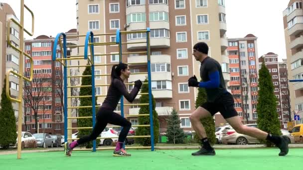 Hermosa Pareja Joven Haciendo Ejercicio Afuera Haciendo Plang Sentadilla Embestidas — Vídeo de stock