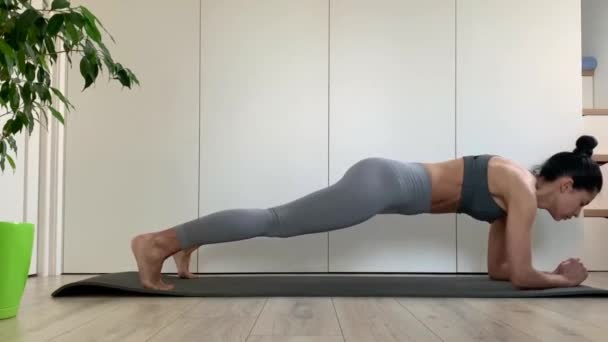 穿着运动服的年轻健康女性在家里或工作室做跳板运动 检疫期间使用的远古木板 做运动锻炼胃肌肉 — 图库视频影像