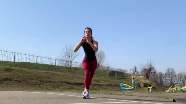 Kadın spor antrenmanı ve sabah dışarıda çalışma. Güçlü ve sportif kadın hamleler yapıyor, çömeliyor, burpee yapıyor.