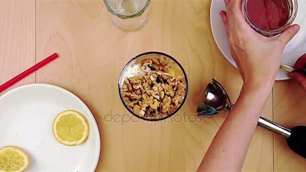 Наливание меда на грецкие орехи в блендер для здорового и питательного смузи — стоковое видео
