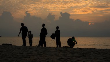 Sunrise plajda siluet insanlara 