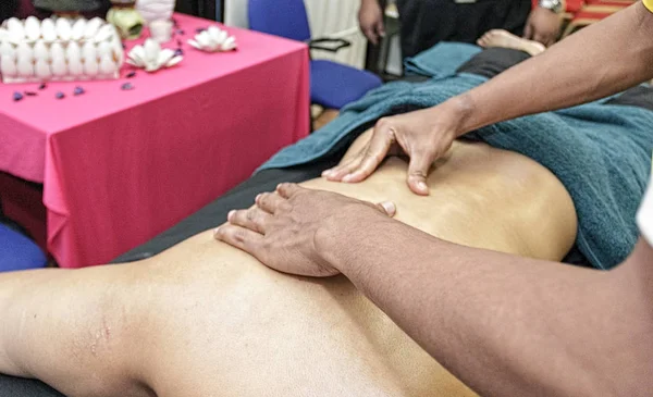 Les mains des hommes font des massages sportifs sur la partie du corps humain — Photo