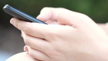 Akıllı telefon kullanan genç bir kadın.