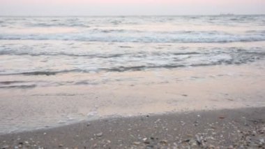 Kumsalda yalınayak günbatımı üzerinde yürüyen kadının bacakları