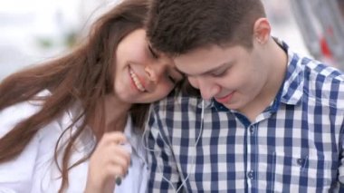 Çift oturma ve sarılma bir smartphone ile müzik paylaşımı