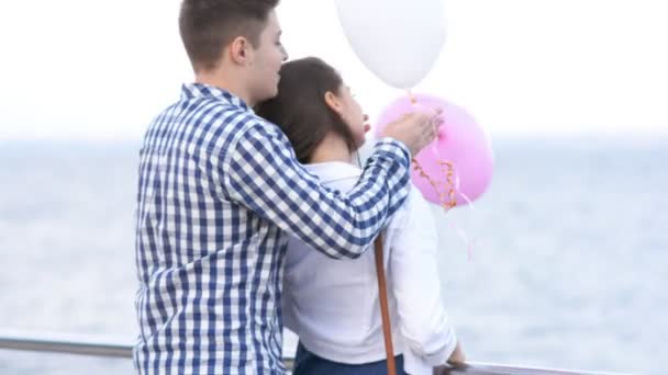 Killen kommer till sin flickvän, sluter ögonen och händerna presenterar baloons — Stockvideo