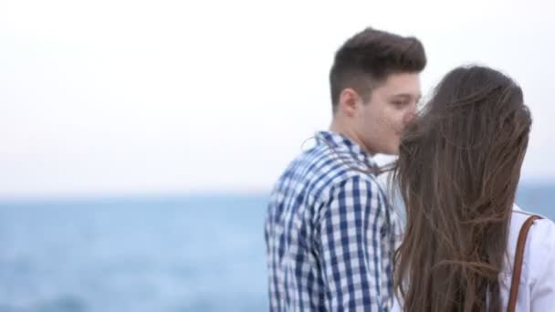 Молода пара тримає руки і ходить біля моря — стокове відео