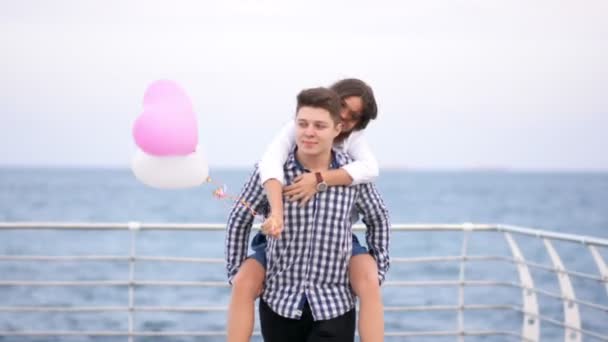 Glad tjej hoppning på pojkvänner tillbaka och kysser honom, par ha kul — Stockvideo