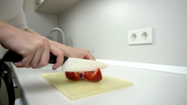Cozinhar - cortar pimenta vermelha na cozinha branca na salada — Vídeo de Stock