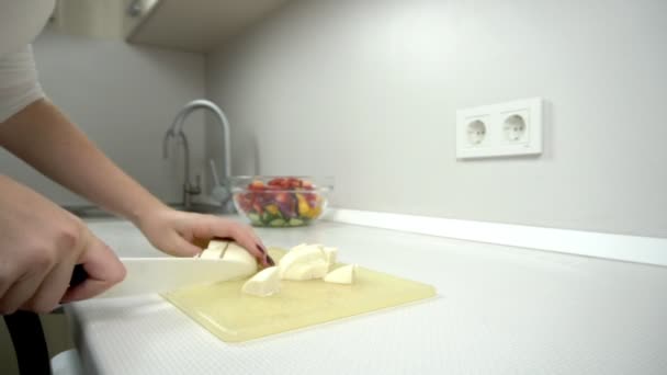 Cocinar - cortar el queso blanco en la cocina en la ensalada — Vídeos de Stock