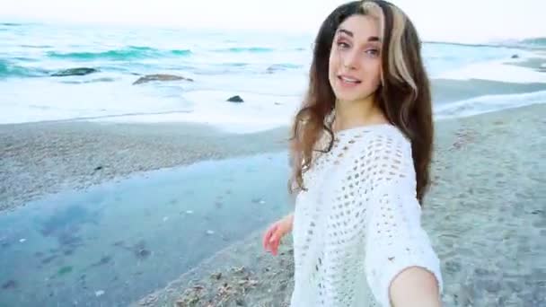 Милая девушка тянет своего парня прося прогулку у моря — стоковое видео